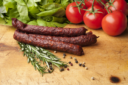 Vegetables and sausages on cutting boardの写真素材