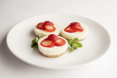 Three cheese cakes on white plateの写真素材