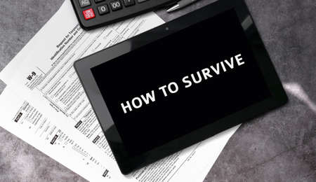How to survive on a black tablet and with tax forms and calculatorの写真素材
