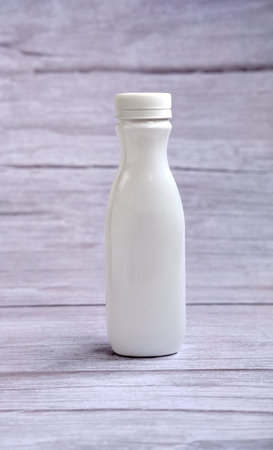 White bottle with a lid on a wooden background