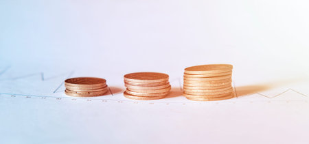 Coins stack lying on chart with dynamics of growth of income from shares