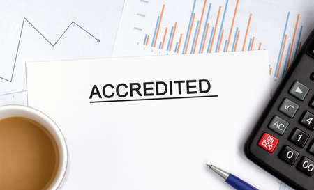 Accredited document with graphs, diagrams and calculator and a cup of fragrant coffeeの写真素材