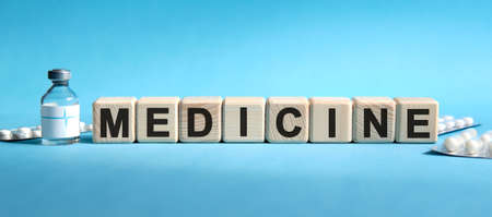 MEDICINE - text on cubes. Drug in ambula, tablets in blisters to reduce disease symptomsの写真素材