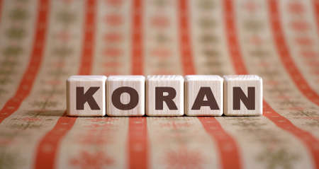 KORAN - holy book, text on wooden cubes on an orange backgroundの写真素材