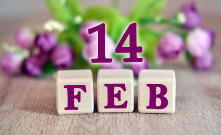 The holiday of February 14 on wooden cubes. Floral background in the background.の写真素材