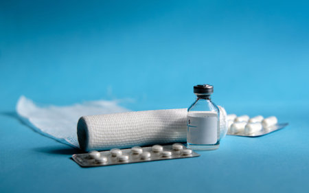 Cotton bandage roll, vial with transparent virus vaccine, white tablets in an antibiotic blister