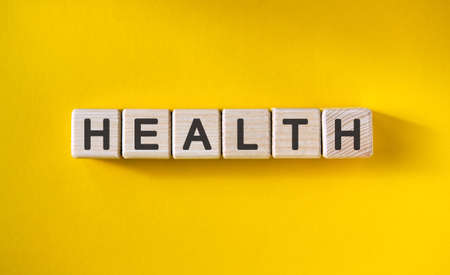 HEALTH - MEDICAL concept on a yellow background. Wooden cubes.の写真素材