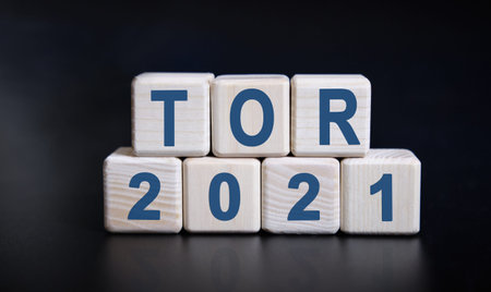 TOR 2021 text on wooden cubes on a black background with reflection.