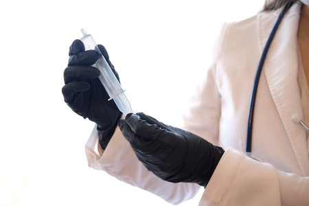 Medic in black gloves, hand with syringe