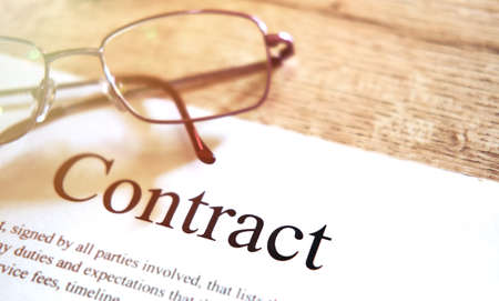 Contract sheet with glasses on a wooden backgroundの写真素材