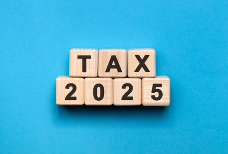 Numbers 2025 and text Tax on cubes on a blue backgroundの写真素材