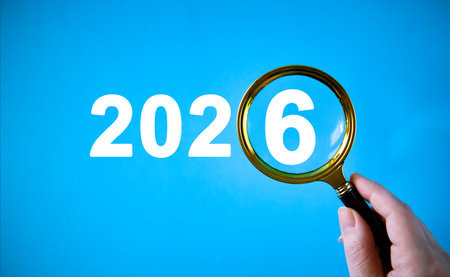 New Years Eve concept with numbers 2026 under a magnifying glass in handの写真素材