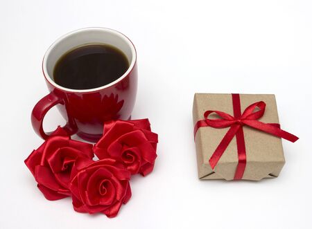 Red coffee cup and gift box with bow. Isolated on white backgroundの写真素材