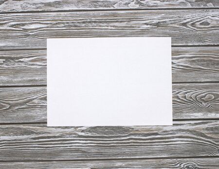 Clean sheet of paper on a wooden table. Mock up photo on timbered background.の写真素材