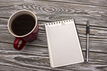 Notebook with coffee on a wooden table. Mock up photo on timbered background.の写真素材