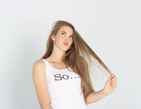 Funny young lady having problem with her hair. Bad haircut with split ends. Female hair care troubleの写真素材