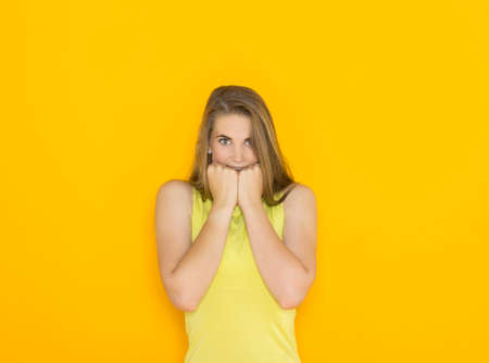 Excited young attractive woman. Funny impatient emotional girl. Studio shot orange backgroundの写真素材