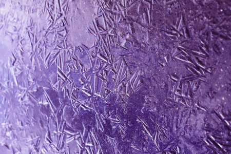 Amazing frosty patterns on the icy surface of a frozen street puddleの写真素材