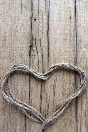 heart of thread on a wooden backgroundの写真素材