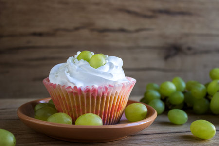 sweet cupcakes with cream and grapesの写真素材