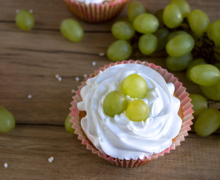 sweet cupcakes with cream and grapesの写真素材
