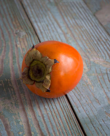 orange persimmon on a wooden boardの写真素材