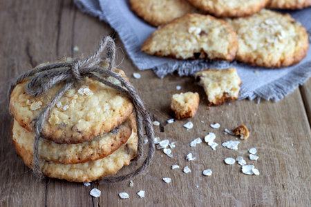 oatmeal cookies on white linen napkin on wooden table. Chocolate chip cookies shot on coffee colored cloth, closeup.の写真素材