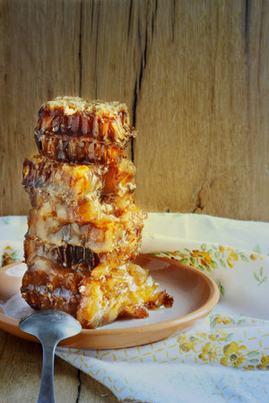 honey in the comb on the wooden table toning