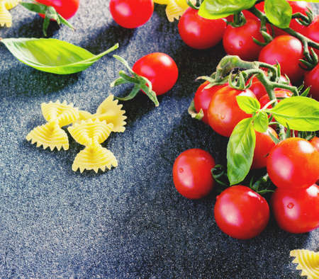 fresh organic cherry tomatoes and paste with basil and garlic on a dark background toningの写真素材