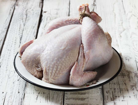 chicken carcass is not cooked on a white wooden backgroundの写真素材