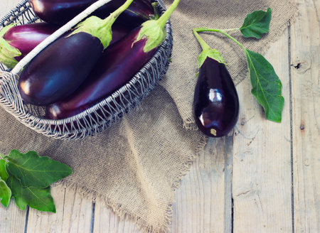 Organic Eggplants and Basket on the wooden background, still life, selective focus toningの写真素材