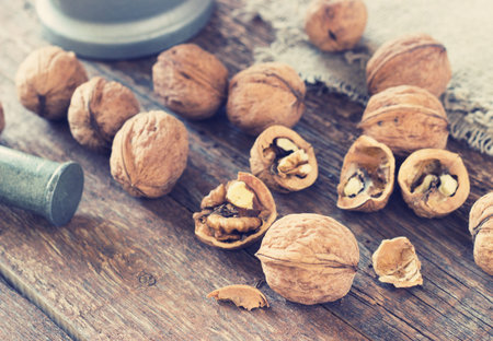 Metal Mortar and walnuts on an old wooden background toning