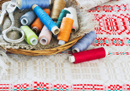 Scissors, bobbins with thread and needles, striped fabric. Old sewing tools .Vintage Backgroundの写真素材