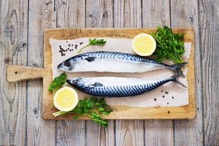 Mackarel at cutting old wooden  table with lemon and parsleyの写真素材