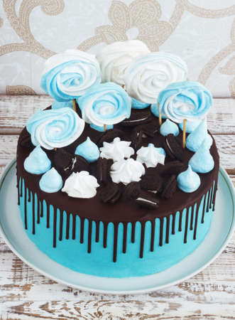 Children's blue cake rainbow color on a white background with wood meringueの写真素材