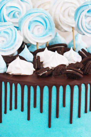 Children's blue cake rainbow color on a white background with wood meringueの写真素材