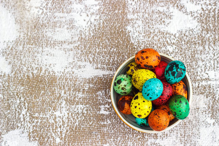 Colored easter eggs on a light canvas background,place for text.