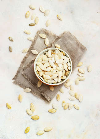 Pumpkin seeds in bowl isolated on white backgroundの写真素材
