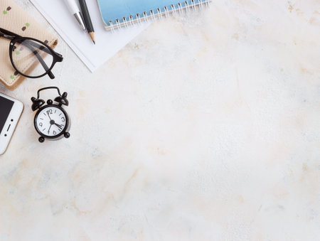 Notepad diary, business card, glasses, clock on a light table. Top view with copy space. Flat Layの写真素材
