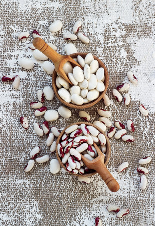 white-pink beans in a wooden cup on a light background