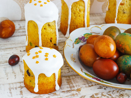Easter composition with orthodox sweet bread, kulich and eggs on light background. Easter holidays...