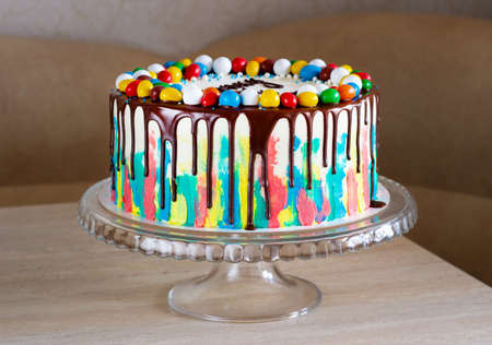 childrens birthday cake with bright strokes of cream and chocolate on the tableの写真素材