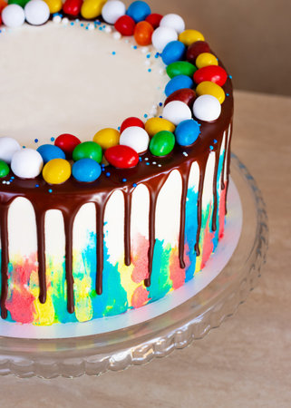 childrens birthday cake with bright strokes of cream and chocolate on the table