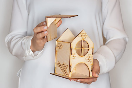 Stay at home. A woman holds a home in her hand. Concept of home stay, quarantine, security inside...