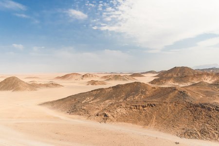 Beautiful Desert Landscape of Egypt. Yellow sand, mountains, clouds and blue sky.の写真素材