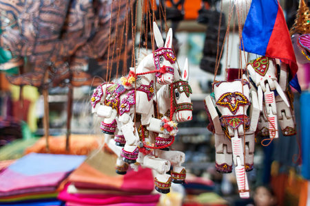 Sale of souvenirs in the market, Siem Reap, Cambodia. Funny handmade wooden puppets donkeys and elephants with bright colorful harness.のeditorial素材