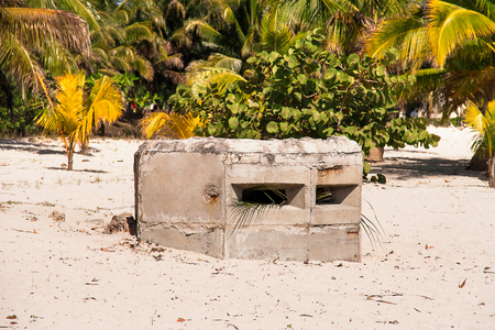 Old earth-and-timber emplacement on caribbean beach of Cuba. Military facility of times of guerrilla war in Cuba.の写真素材