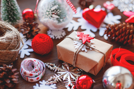 Christmas and New year background with presents, ribbons, balls and different decorations on wooden background. Gift with toy fir tree.の写真素材