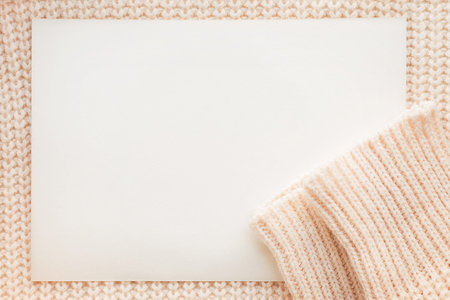 Abstract knitted background with clear paper. Wool sweater with sleeves. Close up picture of ...