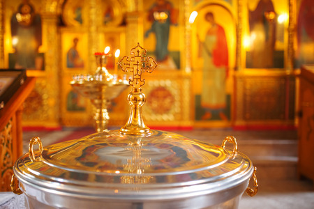 The font for the baptism of children in the Orthodox Church. Symbolic Orthodox gold cross on the cover font.の写真素材